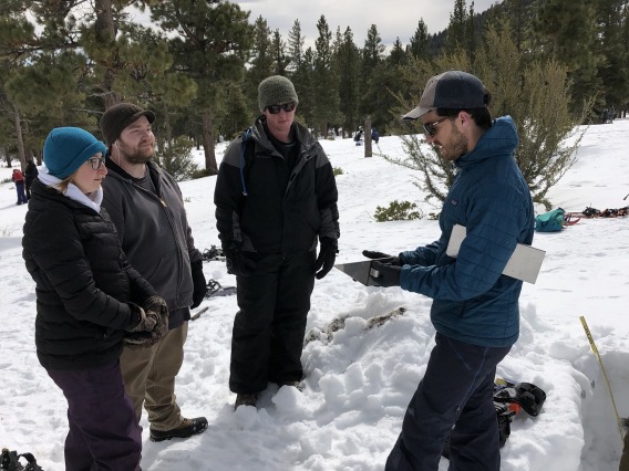 Josh Sturtevant talking to other researchers in the snow