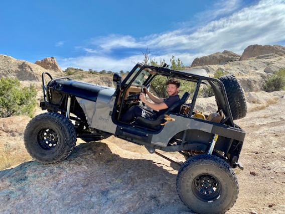 Bryson rock climbing in a Jeep