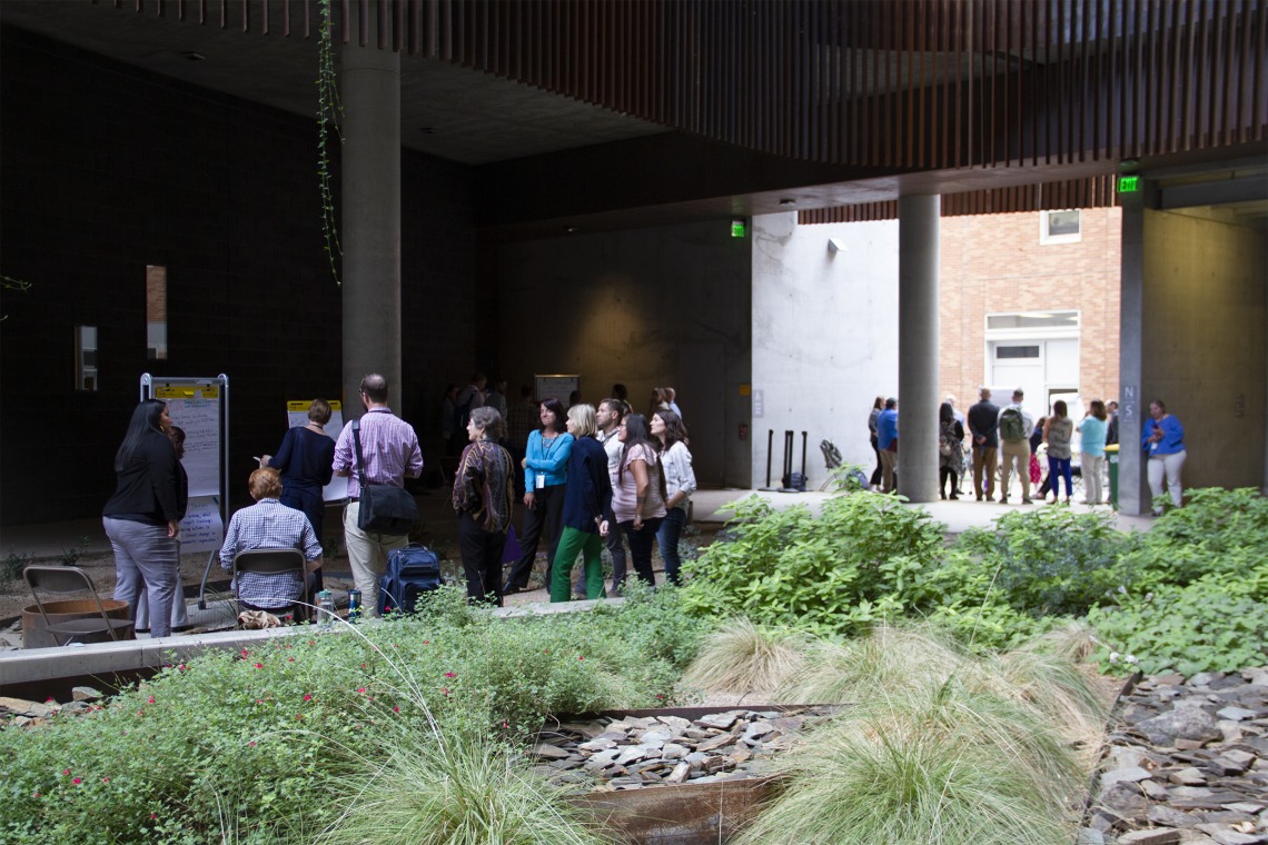 People gathering around research posters in the ENR2 courtyard.