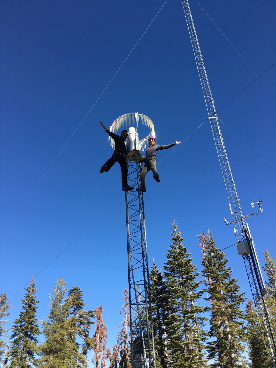 Josh Sturtevant and another researcher on top of a tower holding research equipment