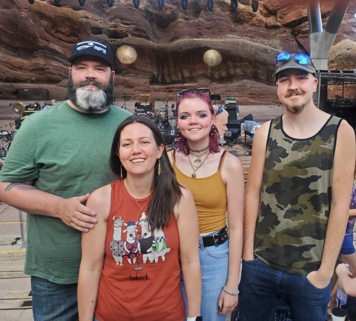 Nicole pictured with friends in front of concert stage